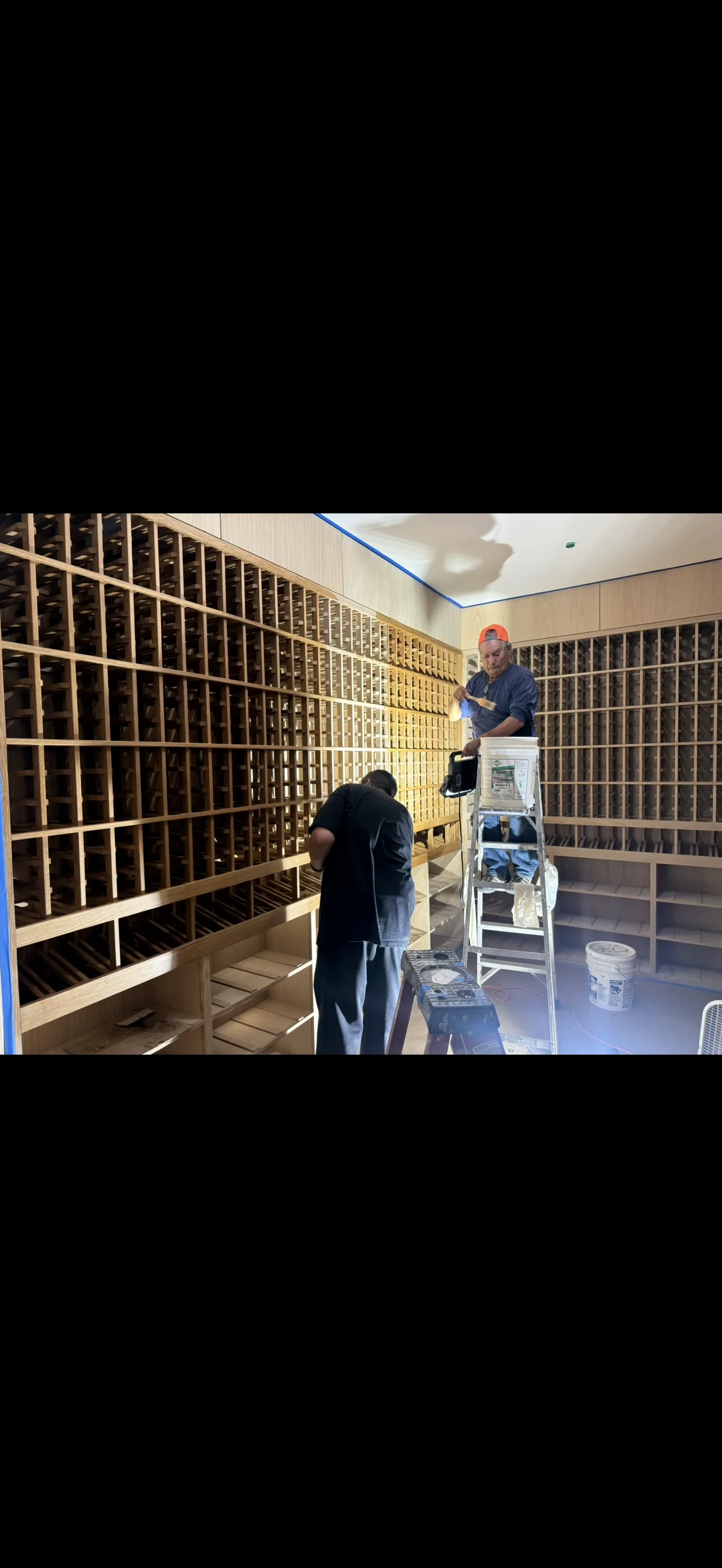 Wood wine cellar cabinetry during finishing work