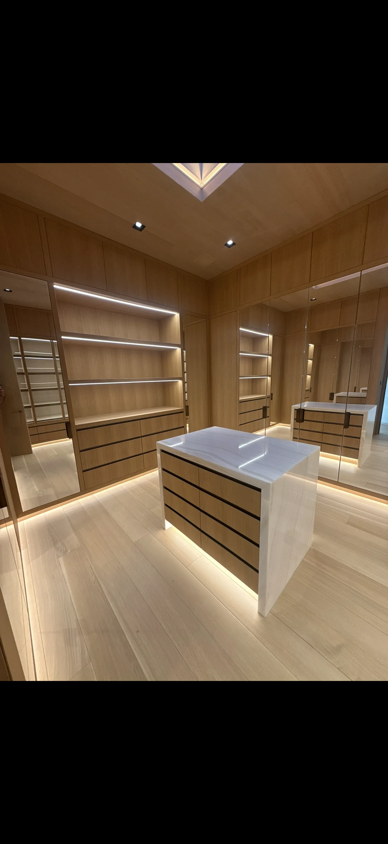 Finished wood cabinetry and island in a dressing room