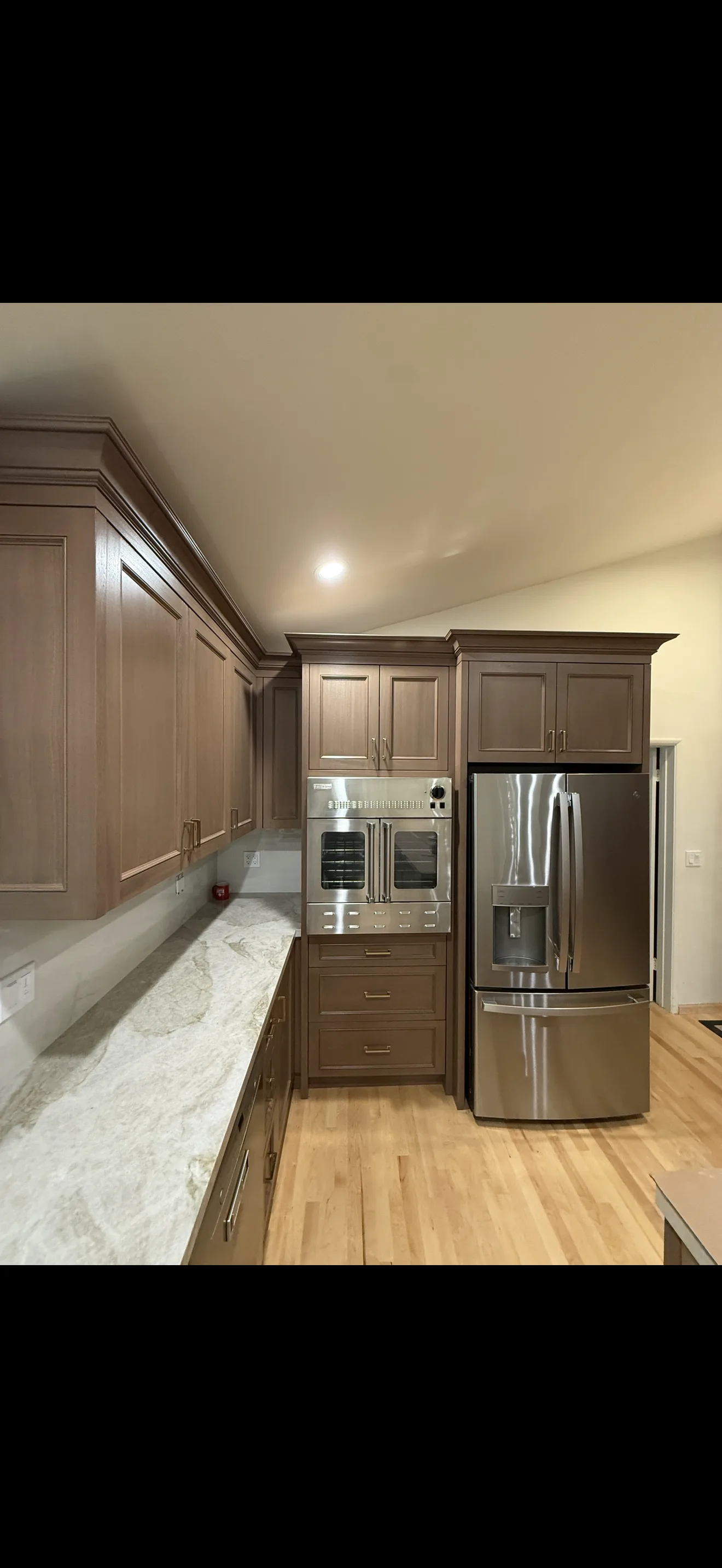 Finished stained kitchen cabinetry with premium appliances